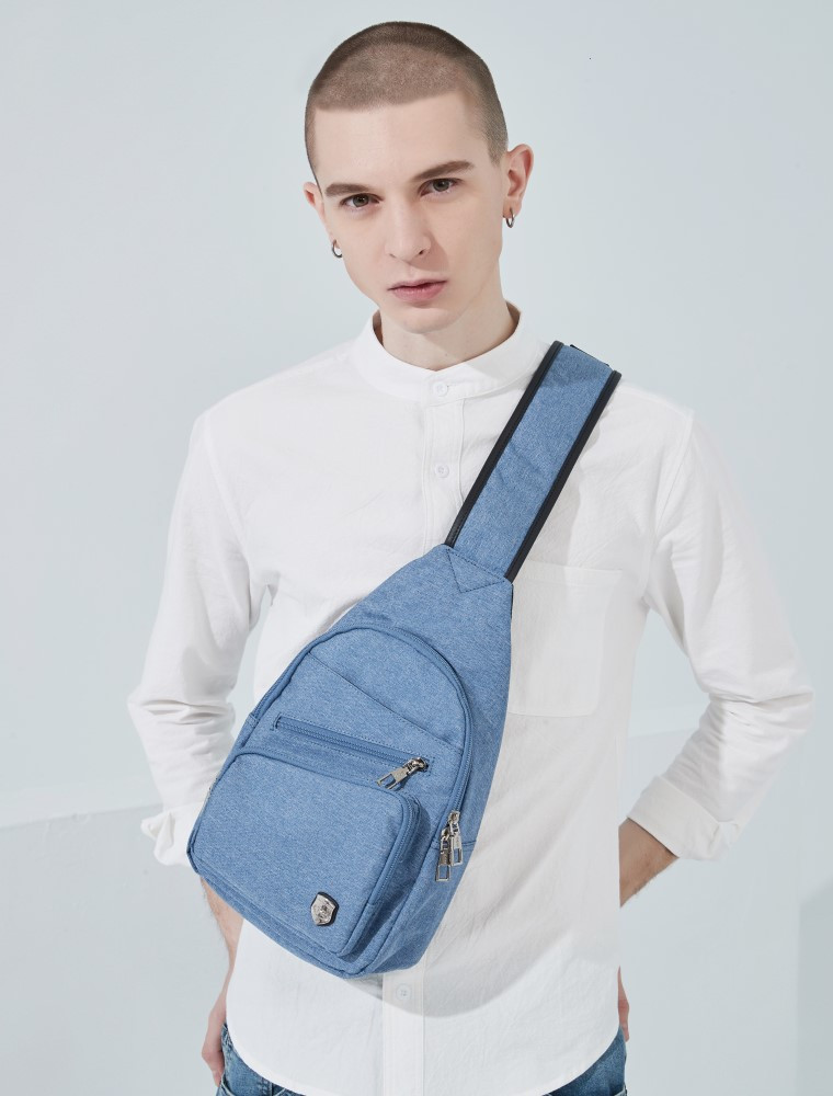 穿著白色T恤與藍色牛仔褲及白色棒球帽，斜背一個小的淺灰色斜肩包。