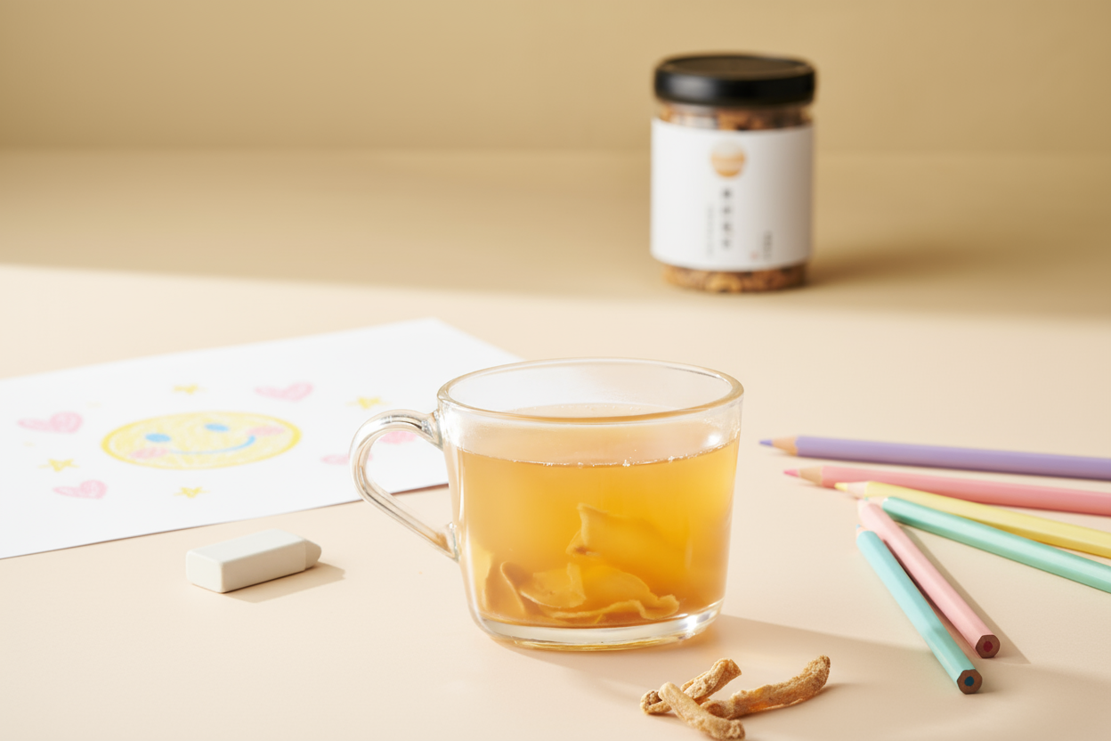 透明玻璃杯盛裝薑草本茶,桌面放有薑片與彩色鉛筆,呈現溫柔日常的生活飲茶畫面