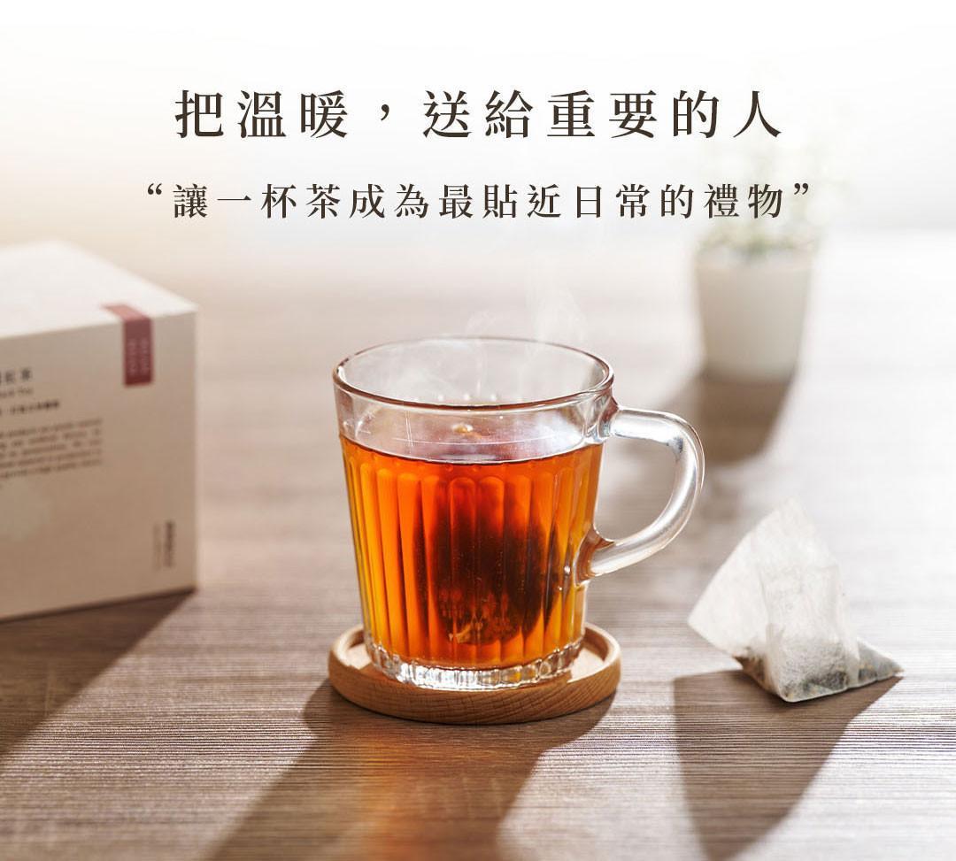 透明玻璃杯沖泡茶包的暖色茶湯情境照，呈現暖暖純手作茶飲溫潤日常。
