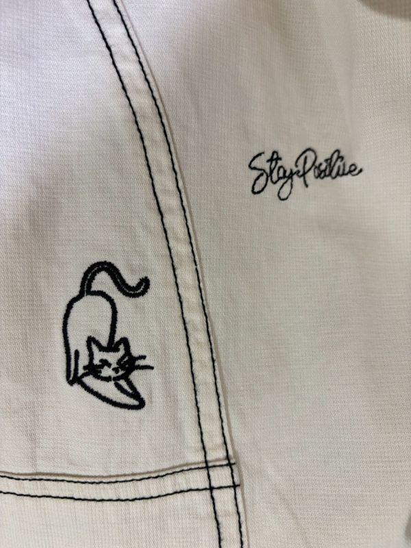 拼接黑車縫線刺繡文字小貓縮口抽繩九分褲 
