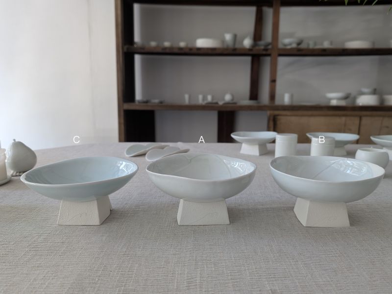 張慢 青瓷方足高台(亮光) 作品多藉由輕柔小心的動作產生指向,在日常感知中搜尋相關記憶,以拆解與重組細微視角,梳理自然及現成物的輪廓與痕跡,讓他們變得輕盈自在、中性,保有更多空間自我詮釋。陶瓷僅是創作的媒材之一,無需限制於實用與非實用、工藝與藝術之間,作品的形成,即是我記錄生活的習慣與方式,人的記憶有限,瞬間記憶更是容易消散,我想將如同視覺暫留的種種,保留在生活當中。