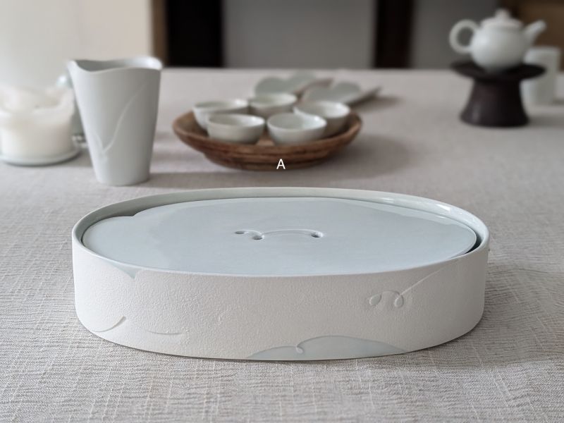 張慢 橢圓青瓷壺承/杯承(大) 作品多藉由輕柔小心的動作產生指向,在日常感知中搜尋相關記憶,以拆解與重組細微視角,梳理自然及現成物的輪廓與痕跡,讓他們變得輕盈自在、中性,保有更多空間自我詮釋。陶瓷僅是創作的媒材之一,無需限制於實用與非實用、工藝與藝術之間,作品的形成,即是我記錄生活的習慣與方式,人的記憶有限,瞬間記憶更是容易消散,我想將如同視覺暫留的種種,保留在生活當中。