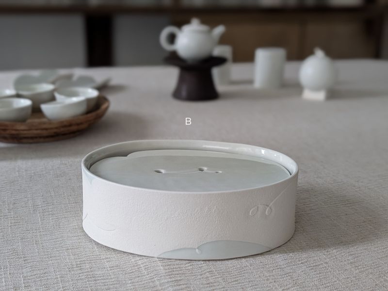 張慢 橢圓青瓷壺承/杯承 作品多藉由輕柔小心的動作產生指向,在日常感知中搜尋相關記憶,以拆解與重組細微視角,梳理自然及現成物的輪廓與痕跡,讓他們變得輕盈自在、中性,保有更多空間自我詮釋。陶瓷僅是創作的媒材之一,無需限制於實用與非實用、工藝與藝術之間,作品的形成,即是我記錄生活的習慣與方式,人的記憶有限,瞬間記憶更是容易消散,我想將如同視覺暫留的種種,保留在生活當中。