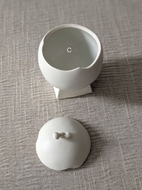 張慢 球型青白瓷茶倉(啞光) 作品多藉由輕柔小心的動作產生指向,在日常感知中搜尋相關記憶,以拆解與重組細微視角,梳理自然及現成物的輪廓與痕跡,讓他們變得輕盈自在、中性,保有更多空間自我詮釋。陶瓷僅是創作的媒材之一,無需限制於實用與非實用、工藝與藝術之間,作品的形成,即是我記錄生活的習慣與方式,人的記憶有限,瞬間記憶更是容易消散,我想將如同視覺暫留的種種,保留在生活當中。