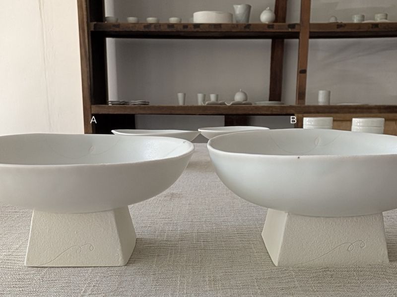 張慢 青白瓷方足高台(啞光) 作品多藉由輕柔小心的動作產生指向,在日常感知中搜尋相關記憶,以拆解與重組細微視角,梳理自然及現成物的輪廓與痕跡,讓他們變得輕盈自在、中性,保有更多空間自我詮釋。陶瓷僅是創作的媒材之一,無需限制於實用與非實用、工藝與藝術之間,作品的形成,即是我記錄生活的習慣與方式,人的記憶有限,瞬間記憶更是容易消散,我想將如同視覺暫留的種種,保留在生活當中。