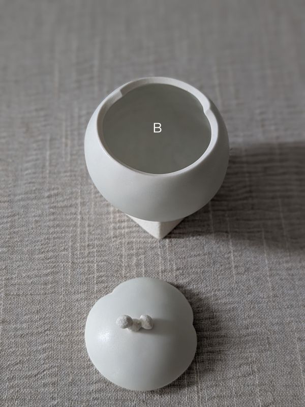 張慢 球型青白瓷茶倉(啞光) 作品多藉由輕柔小心的動作產生指向,在日常感知中搜尋相關記憶,以拆解與重組細微視角,梳理自然及現成物的輪廓與痕跡,讓他們變得輕盈自在、中性,保有更多空間自我詮釋。陶瓷僅是創作的媒材之一,無需限制於實用與非實用、工藝與藝術之間,作品的形成,即是我記錄生活的習慣與方式,人的記憶有限,瞬間記憶更是容易消散,我想將如同視覺暫留的種種,保留在生活當中。