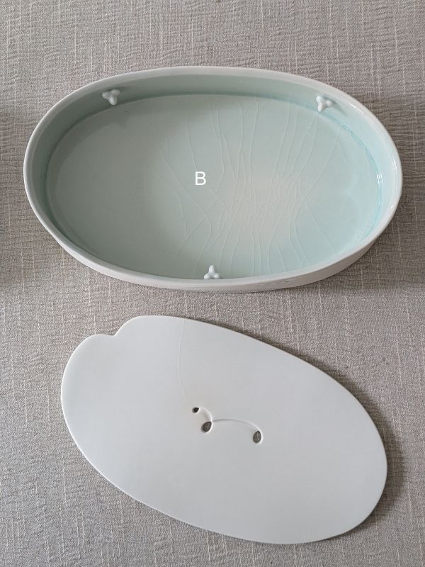 張慢 橢圓青瓷壺承/杯承(大) 作品多藉由輕柔小心的動作產生指向,在日常感知中搜尋相關記憶,以拆解與重組細微視角,梳理自然及現成物的輪廓與痕跡,讓他們變得輕盈自在、中性,保有更多空間自我詮釋。陶瓷僅是創作的媒材之一,無需限制於實用與非實用、工藝與藝術之間,作品的形成,即是我記錄生活的習慣與方式,人的記憶有限,瞬間記憶更是容易消散,我想將如同視覺暫留的種種,保留在生活當中。