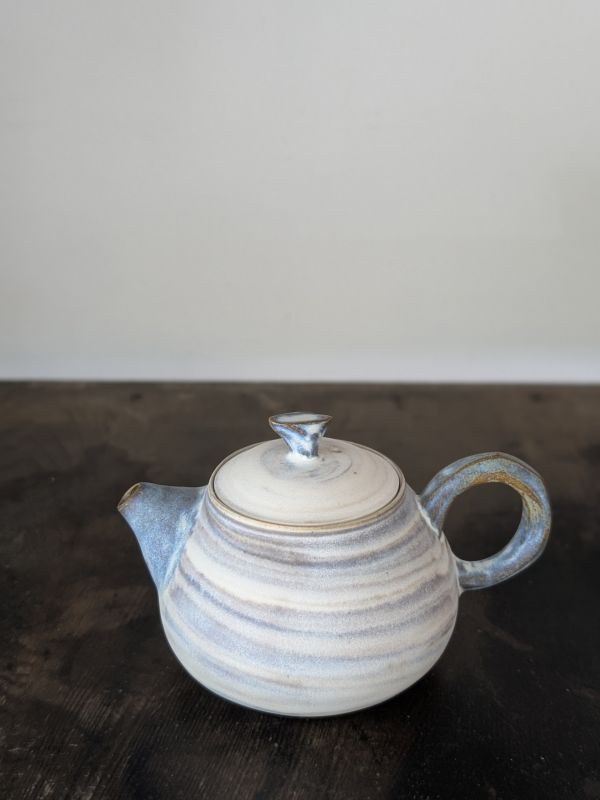 吳慧芳 ｜啞光絞胎 茶壺 《形式之外 Beyond Form》｜吳慧芳 個展
 
當器物不再服膺傳統形式,
創作的秩序,是否能從土裡自由生長？
來自苗栗、深耕陶藝十五年的創作者吳慧芳,長年研習絞胎技法與釉色配製,於火與土之間累積數百次窯燒經驗。此次個展,她選擇放下過往熟悉的節奏與邏輯,以全新釉色與形式語彙,展開一次更靠近內在感知的創作轉身。