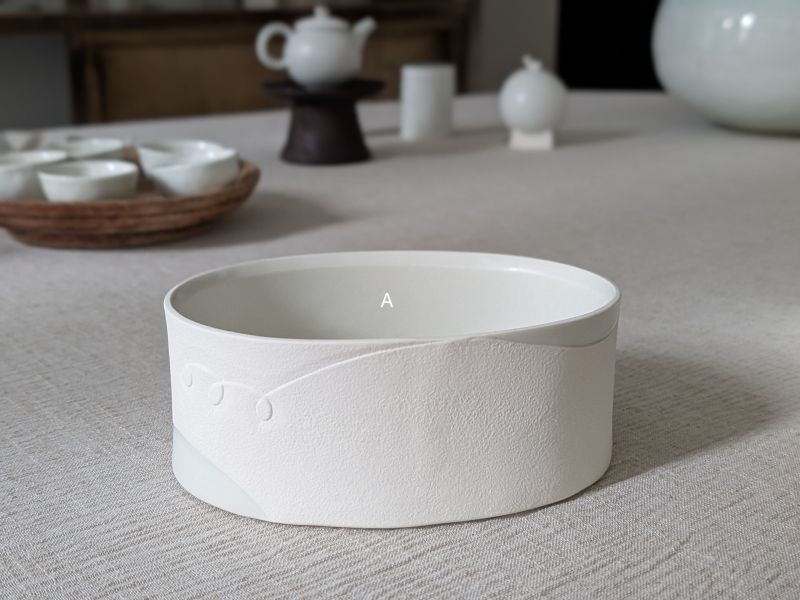張慢 橢圓盒 壺承/花器 作品多藉由輕柔小心的動作產生指向,在日常感知中搜尋相關記憶,以拆解與重組細微視角,梳理自然及現成物的輪廓與痕跡,讓他們變得輕盈自在、中性,保有更多空間自我詮釋。陶瓷僅是創作的媒材之一,無需限制於實用與非實用、工藝與藝術之間,作品的形成,即是我記錄生活的習慣與方式,人的記憶有限,瞬間記憶更是容易消散,我想將如同視覺暫留的種種,保留在生活當中。