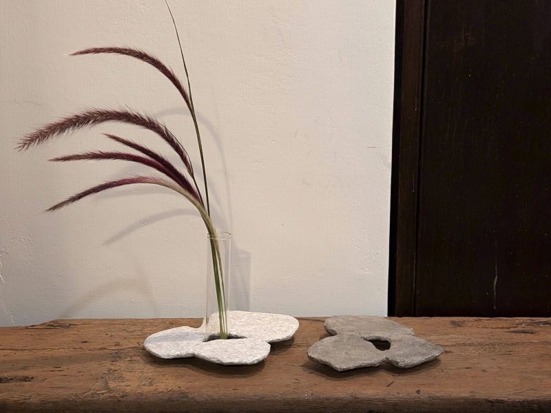 日青屾行 紙塑桌面擺件/花器 落日酒矸系列》紙塑系列花器 作品

「酒矸倘賣嘸 酒矸倘賣嘸…… 」源自兒時記憶的歌曲,此系列花器都是以日常可得的玻璃瓶罐為基底,外觀搭配創作上擅長使用的材料「紙漿」塑造,強化本身的實用性,也強調材料本身的再生性。

外型上參照植物或是有機體去變形,也不全然都是自行塑造出來,有時也依附瓶罐本身的造型下去做變化,因此每一隻花器本身都略有不同,也享受這種很隨機性的創作過程。顏色表現上喜歡不飽和