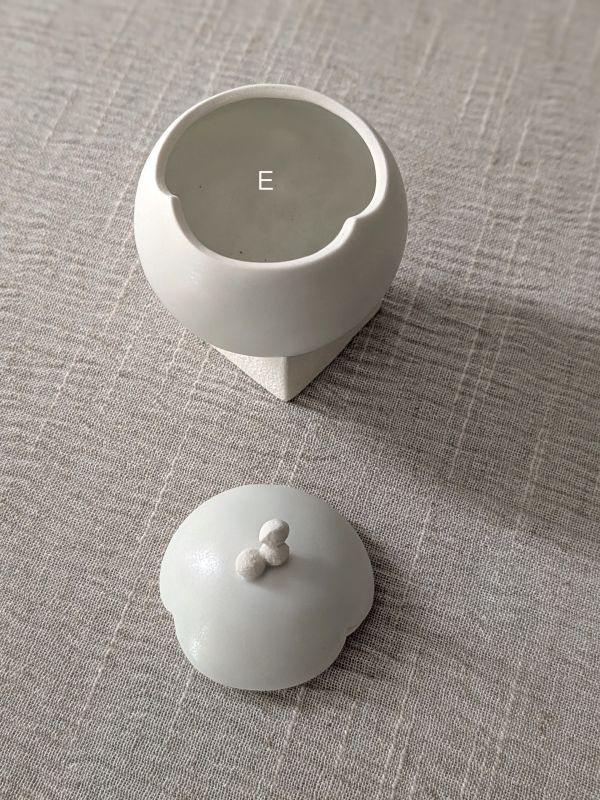 張慢 球型青白瓷茶倉(啞光) 作品多藉由輕柔小心的動作產生指向,在日常感知中搜尋相關記憶,以拆解與重組細微視角,梳理自然及現成物的輪廓與痕跡,讓他們變得輕盈自在、中性,保有更多空間自我詮釋。陶瓷僅是創作的媒材之一,無需限制於實用與非實用、工藝與藝術之間,作品的形成,即是我記錄生活的習慣與方式,人的記憶有限,瞬間記憶更是容易消散,我想將如同視覺暫留的種種,保留在生活當中。