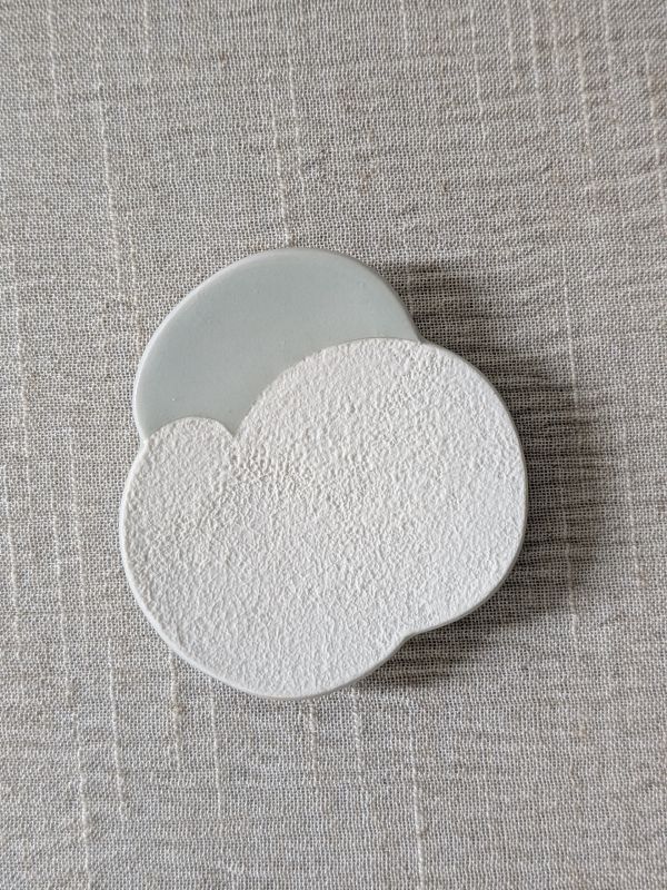 張慢 青瓷杯托/豆皿 作品多藉由輕柔小心的動作產生指向,在日常感知中搜尋相關記憶,以拆解與重組細微視角,梳理自然及現成物的輪廓與痕跡,讓他們變得輕盈自在、中性,保有更多空間自我詮釋。陶瓷僅是創作的媒材之一,無需限制於實用與非實用、工藝與藝術之間,作品的形成,即是我記錄生活的習慣與方式,人的記憶有限,瞬間記憶更是容易消散,我想將如同視覺暫留的種種,保留在生活當中。