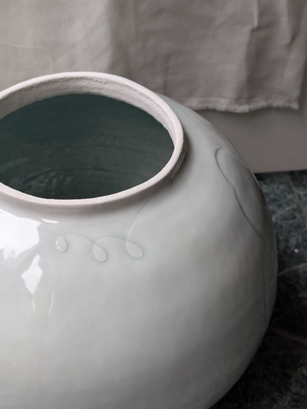 張慢 青瓷大花器 作品多藉由輕柔小心的動作產生指向,在日常感知中搜尋相關記憶,以拆解與重組細微視角,梳理自然及現成物的輪廓與痕跡,讓他們變得輕盈自在、中性,保有更多空間自我詮釋。陶瓷僅是創作的媒材之一,無需限制於實用與非實用、工藝與藝術之間,作品的形成,即是我記錄生活的習慣與方式,人的記憶有限,瞬間記憶更是容易消散,我想將如同視覺暫留的種種,保留在生活當中。