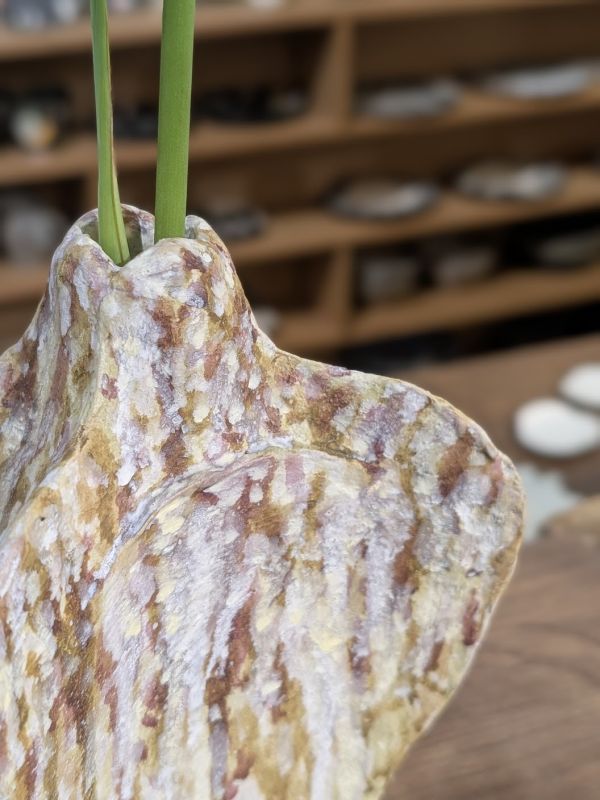 日青屾行 紙塑花器-3 落日酒矸系列》紙塑系列花器 作品

「酒矸倘賣嘸 酒矸倘賣嘸…… 」源自兒時記憶的歌曲,此系列花器都是以日常可得的玻璃瓶罐為基底,外觀搭配創作上擅長使用的材料「紙漿」塑造,強化本身的實用性,也強調材料本身的再生性。

外型上參照植物或是有機體去變形,也不全然都是自行塑造出來,有時也依附瓶罐本身的造型下去做變化,因此每一隻花器本身都略有不同,也享受這種很隨機性的創作過程。顏色表現上喜歡不飽和