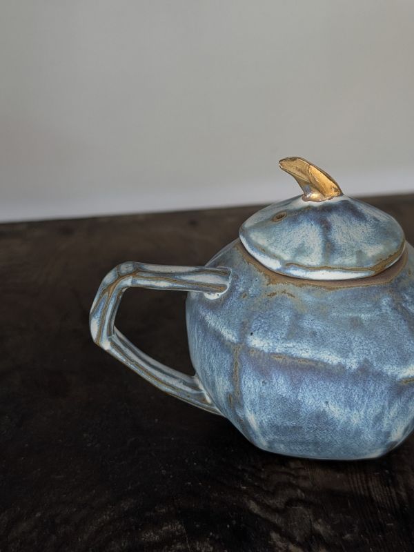 吳慧芳 ｜金鈕藍墨 茶壺 《形式之外 Beyond Form》｜吳慧芳 個展
 
當器物不再服膺傳統形式,
創作的秩序,是否能從土裡自由生長？
來自苗栗、深耕陶藝十五年的創作者吳慧芳,長年研習絞胎技法與釉色配製,於火與土之間累積數百次窯燒經驗。此次個展,她選擇放下過往熟悉的節奏與邏輯,以全新釉色與形式語彙,展開一次更靠近內在感知的創作轉身。