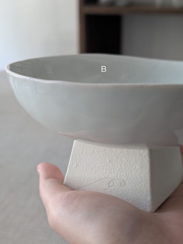 張慢 青瓷方足高台(亮光) 作品多藉由輕柔小心的動作產生指向,在日常感知中搜尋相關記憶,以拆解與重組細微視角,梳理自然及現成物的輪廓與痕跡,讓他們變得輕盈自在、中性,保有更多空間自我詮釋。陶瓷僅是創作的媒材之一,無需限制於實用與非實用、工藝與藝術之間,作品的形成,即是我記錄生活的習慣與方式,人的記憶有限,瞬間記憶更是容易消散,我想將如同視覺暫留的種種,保留在生活當中。