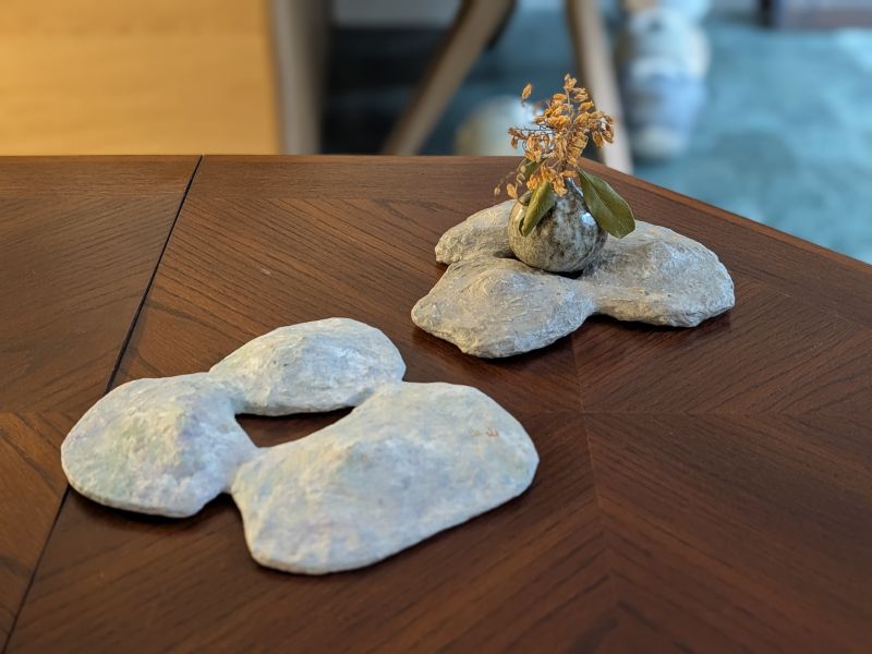 日青屾行 紙塑桌面擺件/花器 落日酒矸系列》紙塑系列花器 作品

「酒矸倘賣嘸 酒矸倘賣嘸…… 」源自兒時記憶的歌曲,此系列花器都是以日常可得的玻璃瓶罐為基底,外觀搭配創作上擅長使用的材料「紙漿」塑造,強化本身的實用性,也強調材料本身的再生性。

外型上參照植物或是有機體去變形,也不全然都是自行塑造出來,有時也依附瓶罐本身的造型下去做變化,因此每一隻花器本身都略有不同,也享受這種很隨機性的創作過程。顏色表現上喜歡不飽和