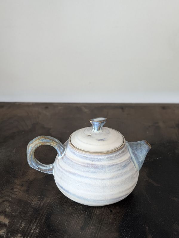 吳慧芳 ｜啞光絞胎 茶壺 《形式之外 Beyond Form》｜吳慧芳 個展
 
當器物不再服膺傳統形式,
創作的秩序,是否能從土裡自由生長？
來自苗栗、深耕陶藝十五年的創作者吳慧芳,長年研習絞胎技法與釉色配製,於火與土之間累積數百次窯燒經驗。此次個展,她選擇放下過往熟悉的節奏與邏輯,以全新釉色與形式語彙,展開一次更靠近內在感知的創作轉身。