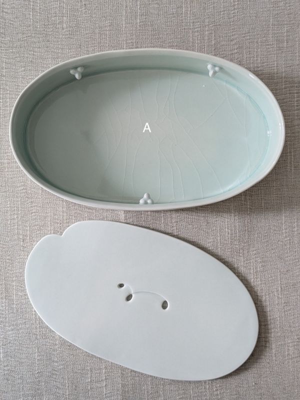張慢 橢圓青瓷壺承/杯承(大) 作品多藉由輕柔小心的動作產生指向,在日常感知中搜尋相關記憶,以拆解與重組細微視角,梳理自然及現成物的輪廓與痕跡,讓他們變得輕盈自在、中性,保有更多空間自我詮釋。陶瓷僅是創作的媒材之一,無需限制於實用與非實用、工藝與藝術之間,作品的形成,即是我記錄生活的習慣與方式,人的記憶有限,瞬間記憶更是容易消散,我想將如同視覺暫留的種種,保留在生活當中。