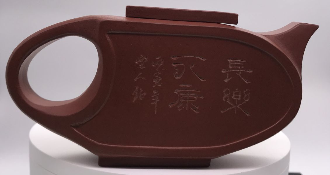 1980年(紫砂)(紅土)扁壓橢圓壺(作者:徐萍(樂人刻)) 