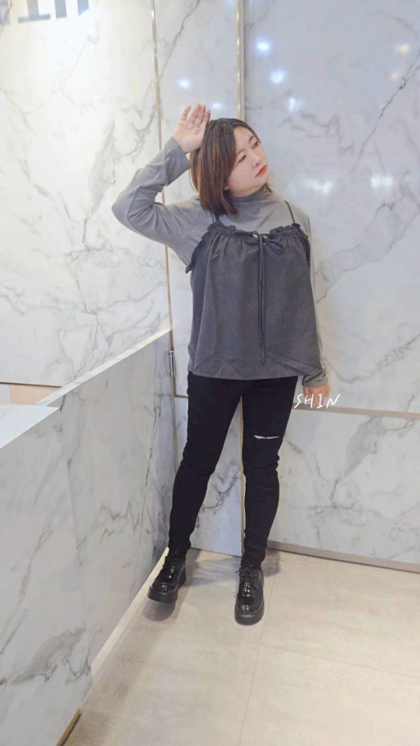 一顆釦割破黑色牛仔褲 