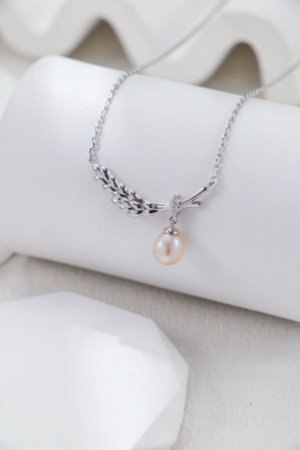 Feather 羽翼珍珠項鍊 Feather Grace Pearl Necklace以羽翼守護為靈感,結合珍珠垂墜設計,呈現溫柔與堅定並存的氣質。提供金／銀兩色,為日常造型添上一抹優雅祝福