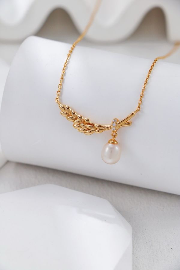 Feather 羽翼珍珠項鍊 Feather Grace Pearl Necklace以羽翼守護為靈感,結合珍珠垂墜設計,呈現溫柔與堅定並存的氣質。提供金／銀兩色,為日常造型添上一抹優雅祝福